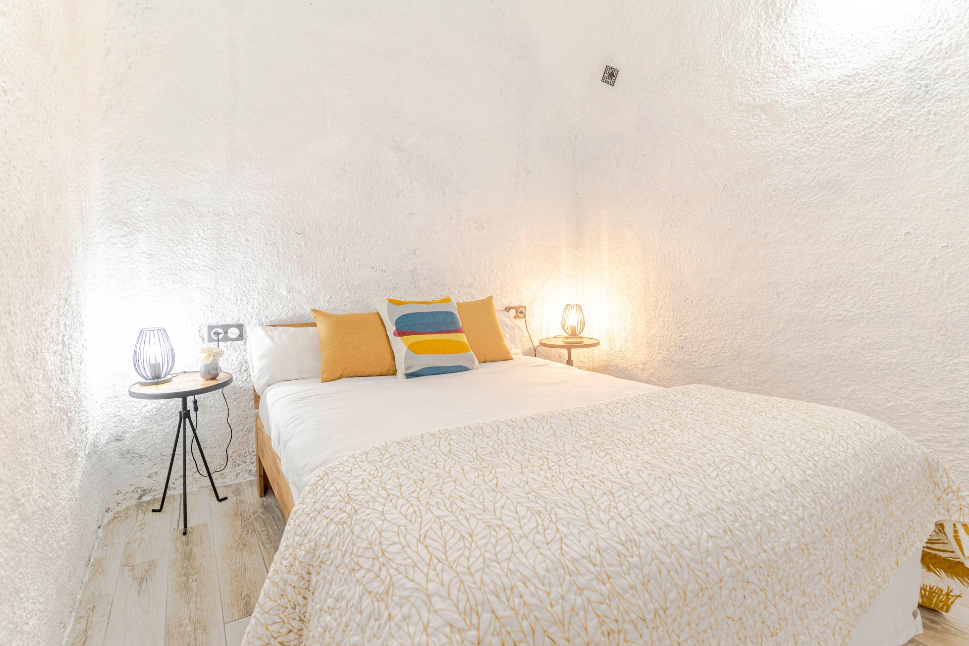 Dormitorio principal en cueva — paredes texturizadas y luz cálida